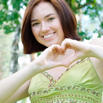 Smiling Girl making heart from hands